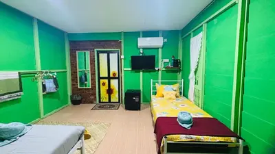 a room with green walls and a bed in it at Capital O 91187 D'dusun Raudhah Chalet in Baling