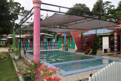 a pool in front of a building with a pink pole at Capital O 91187 D'dusun Raudhah Chalet in Baling