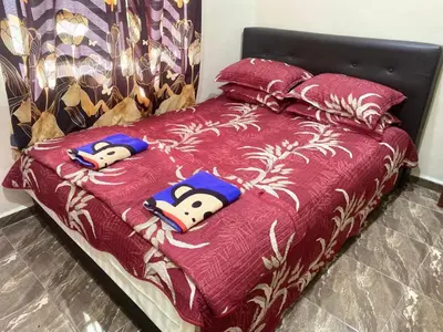 a bed with a red comforter with hello kitty pillows at Capital O 91191 Chalet Cd Impiana in Kulim