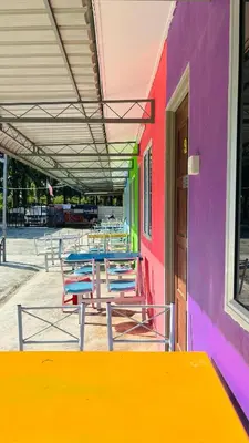 a group of tables and chairs in front of a building at Capital O 91191 Chalet Cd Impiana in Kulim