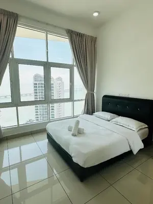 a large bed in a room with large windows at Southbay Seaview Condo A31 #10minQueensbay in Bayan Lepas