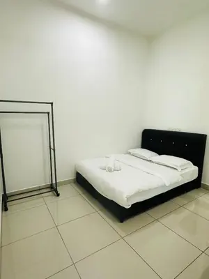 a bed in a white room with a mirror at Southbay Seaview Condo A31 #10minQueensbay in Bayan Lepas