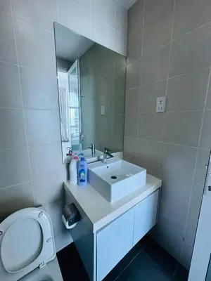 a bathroom with a sink and a toilet and a mirror at Southbay Seaview Condo A31 #10minQueensbay in Bayan Lepas