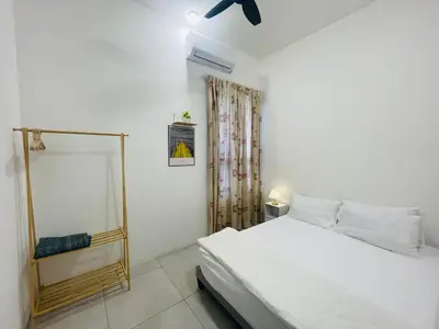a white bedroom with a bed and a window at Aston Acacia Homestay in Bukit Mertajam