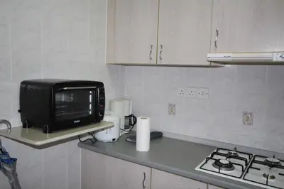 a kitchen counter with a microwave and a television at Eden Seaview in Batu Ferringhi