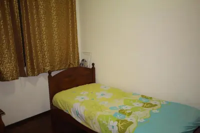 a small bed in a bedroom with a curtain at Eden Seaview in Batu Ferringhi
