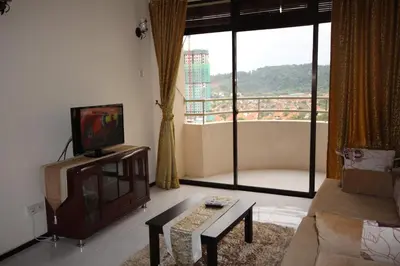a living room with a flat screen tv and a couch at Eden Seaview in Batu Ferringhi