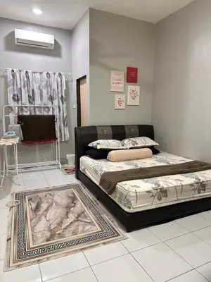 a bedroom with two beds and a rug at MrsSafiyya Homestay in Tanjung Rambutan