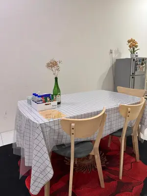 a table with two chairs and a white table cloth at MrsSafiyya Homestay in Tanjung Rambutan