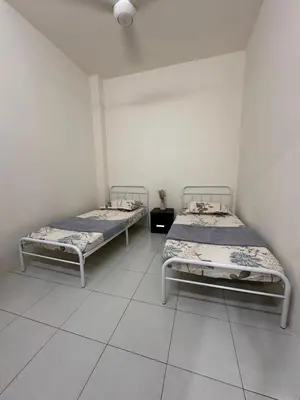 two beds in a room with white walls at MrsSafiyya Homestay in Tanjung Rambutan