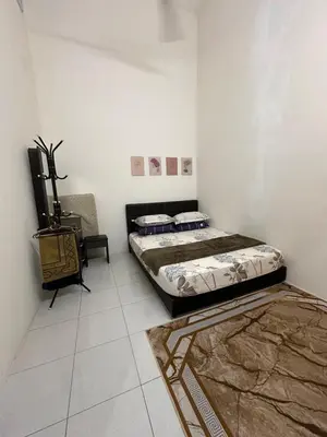 two beds sitting in a room with white walls at MrsSafiyya Homestay in Tanjung Rambutan