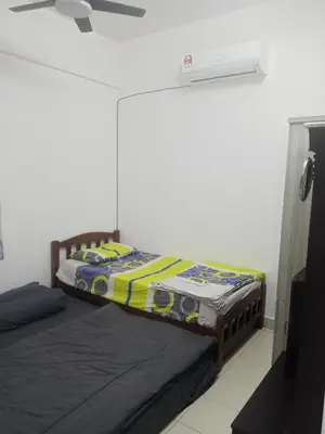 a bedroom with two twin beds and a fan at Little sweet homestay in Ipoh