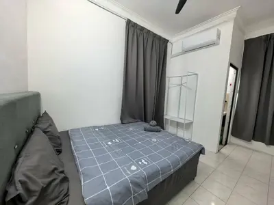 a bedroom with a bed with a blue comforter at Queen Bed Budget Room in Padang Serai