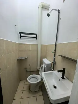 a bathroom with a toilet and a sink at Queen Bed Budget Room in Padang Serai