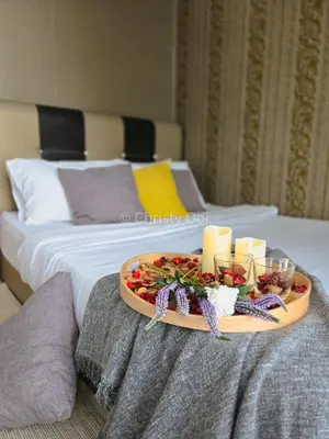 a tray with candles and flowers on a bed at NEW 2BR Sunrise Gurney with Stunning Seaview \u65e0\u654c\u65e5\u51fa\u6d77\u666f\u623f in George Town