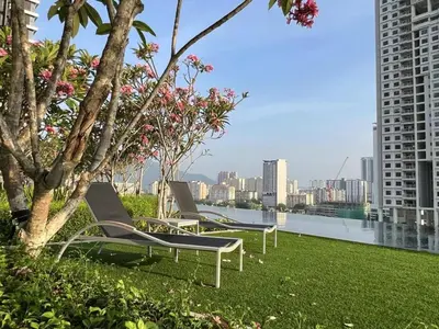 two lounge chairs sitting on top of a green lawn at Stylish city center infinity pool unbeatable night view near to attractions, food, family friendly in Jelutong