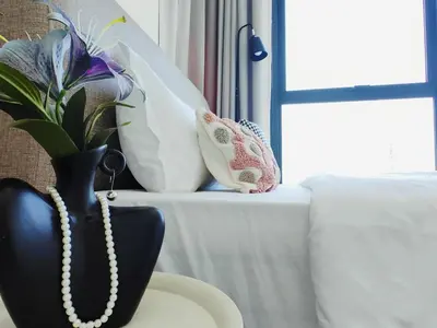 a black vase with a pearl necklace on a table at Stylish city center infinity pool unbeatable night view near to attractions, food, family friendly in Jelutong