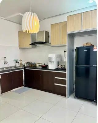 a kitchen with a black refrigerator and wooden cabinets at Dandelion 3BR Apt Near lake garden in Taiping