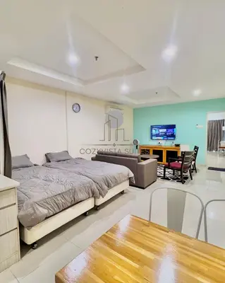 a bedroom with a bed and a couch and a table at CozyVista Suites Marina Island Lumut Perak in Gua Sai