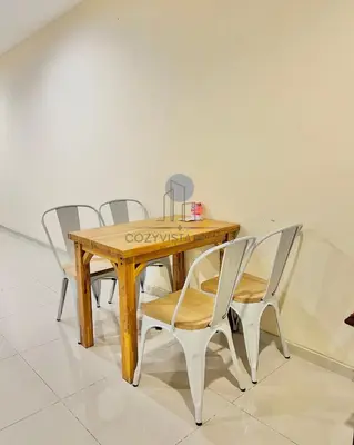 a wooden table with four chairs around it at CozyVista Suites Marina Island Lumut Perak in Gua Sai