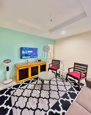 a living room with two chairs and a tv at CozyVista Suites Marina Island Lumut Perak in Gua Sai