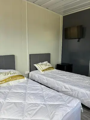two beds sitting next to each other in a room at Roomstay Kontena Sungai Bioh in Gua Sai