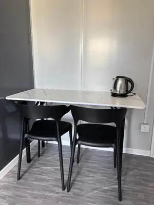 a table with two chairs and a tea kettle on it at Roomstay Kontena Sungai Bioh in Gua Sai