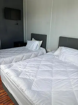 two white beds sitting next to each other in a bedroom at Roomstay Kontena Sungai Bioh in Gua Sai