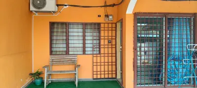 an orange building with a chair in front of a door at Homestay Bonda D' in TanjongMalim