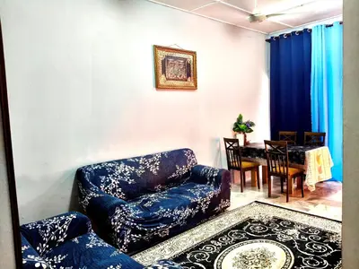 a living room with a blue couch and a table at Homestay Bonda D' in TanjongMalim