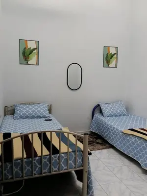 a bedroom with two beds and a mirror at Homestay Bonda D' in TanjongMalim