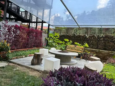 a garden with a table and benches in a greenhouse at Room 11 by 10 Mentigi in Tanah Rata