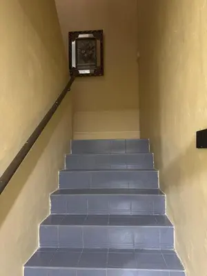 a staircase with blue steps with a picture on the wall at Homestay NIA Chukai in Gua Sai