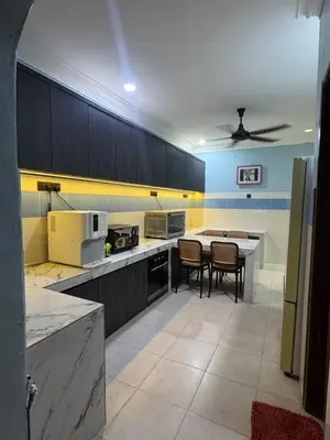 a large kitchen with a table and chairs in it at Homestay NIA Chukai in Gua Sai
