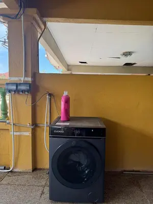 a washing machine with a pink bottle on top of it at Homestay NIA Chukai in Gua Sai