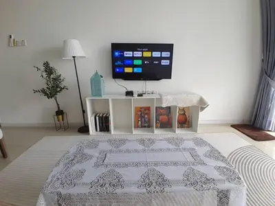 a living room with a television and a table with a rug at Condominium Crystal Heights in Taiping