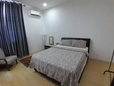 a bedroom with a bed and a chair at Condominium Crystal Heights in Taiping