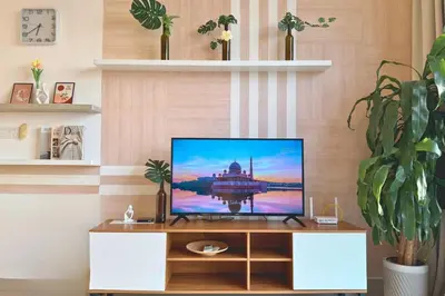 a television sitting on a cabinet in a living room at Sunset View Stay at Conezion IOI in Gua Sai