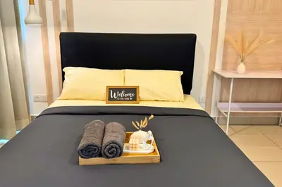 a bed with a tray with towels on it at Sunset View Stay at Conezion IOI in Gua Sai