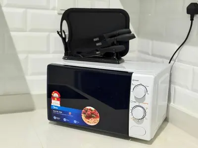 a microwave with a box on top of it at Iconic Regency Service Residences - Bee's Home in Bayan Lepas