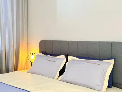 a bed with two white pillows on top of it at Iconic Regency Service Residences - Bee's Home in Bayan Lepas