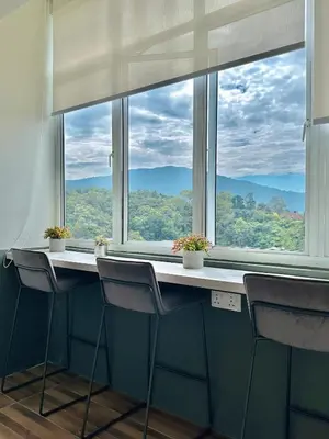a room with a table and chairs and a large window at Tanah Rata Cameron Jaya cottage has plenty of hot water, a spacious living room in Tanah Rata