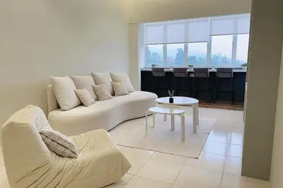 a white living room with a couch and a table at Tanah Rata Cameron Jaya cottage has plenty of hot water, a spacious living room in Tanah Rata