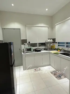 a kitchen with white cabinets and a black refrigerator at Tanah Rata Cameron Jaya cottage has plenty of hot water, a spacious living room in Tanah Rata