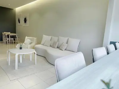 a living room with a white couch and a table at Tanah Rata Cameron Jaya cottage has plenty of hot water, a spacious living room in Tanah Rata