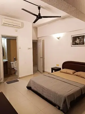 a bedroom with a bed and a ceiling fan at Sri Sayang Resort Apartment in Batu Ferringhi