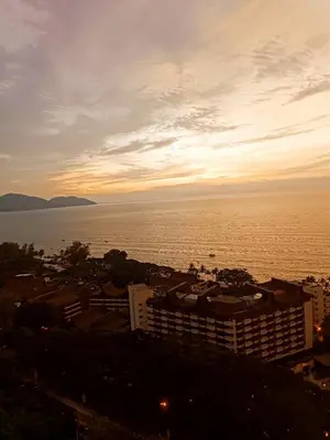 a view of the ocean at sunset at Sri Sayang Resort Apartment in Batu Ferringhi