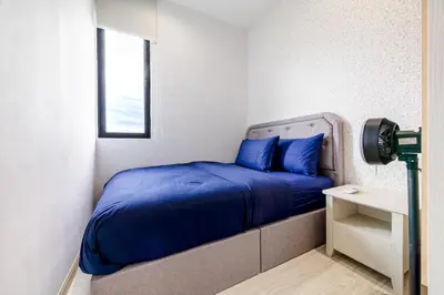 a bedroom with a bed with blue pillows and a window at IconicRegency #3BR #USM #Queensbay #Airport in Bayan Lepas