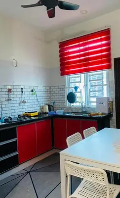 a kitchen with red cabinets and a red window at ZuLee Homestay in Lunas
