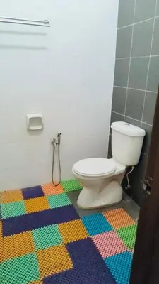 a bathroom with a toilet and a colorful floor at ZuLee Homestay in Lunas